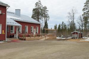 a red building with a deck next to a house at Kairalan Kievari in Salla