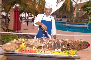 a man standing next to a large fish on a table at Royal Saly in Saly Portudal