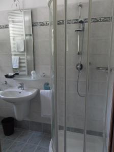 La salle de bains est pourvue d'une douche et d'un lavabo. dans l'établissement Hotel Tyrolia, à Malga Ciapela