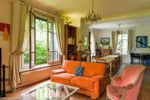 salon z pomarańczową kanapą i krzesłami w obiekcie Villa Ariane w mieście Saint-Jorioz