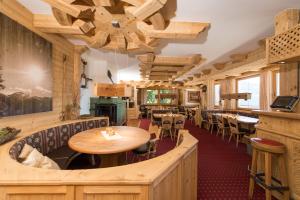 PillにあるFrieden DAS Alpine Panorama Hotelの木製の壁とテーブルと椅子が備わるレストラン