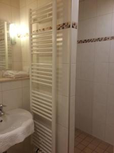ハノーファーシュ・ミュンデンにあるSchmucker Jäger - Hotel Garniの白いバスルーム(シャワー、シンク付)