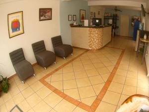 una sala de espera con 2 sillas y un mostrador en Hotel Rio Balsas en Manzanillo