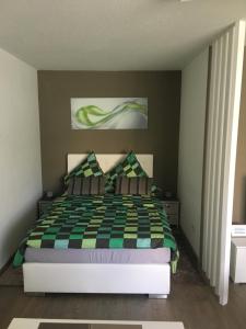 - une chambre avec un lit et une couverture en damier dans l'établissement Bürgemeister Apartment, à Augsbourg