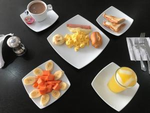 a table with plates of food and a cup of coffee at Hotel Metropolitano in Neiva