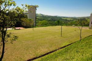 a grassy area with a fence and trees at Canto da Floresta Ecoresort in Amparo
