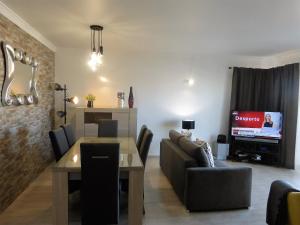 ein Wohnzimmer mit einem Sofa, einem Tisch und einem TV in der Unterkunft Lucas' House in Lagos