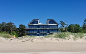 a large building on top of a sandy beach at Apartamenty Amon z widokiem na morze in Darlowko