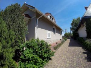a white house with a pathway next to a building at Bodza Vendégház in Balatonfüred