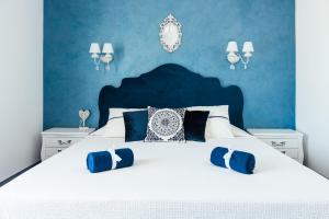 a blue bedroom with a white bed with blue walls at Hotel Hermes Budva in Budva