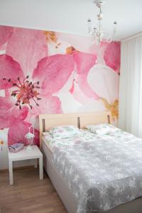 a bedroom with a bed with pink flowers on the wall at Lahti Lehti House in Lahti