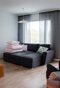 a living room with a black couch in front of a window at Lahti Lehti House in Lahti