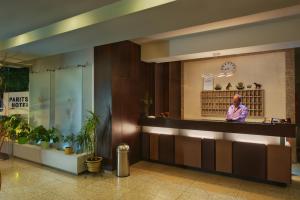 a woman standing behind a counter in a lobby at Paritsa Hotel in Kos