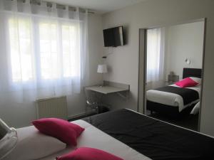 Les Hautes-RivièresにあるAuberge en Ardenneのベッド2台と鏡が備わるホテルルームです。