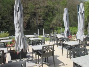 a group of tables with umbrellas and chairs at Auberge en Ardenne in Les Hautes-Rivières