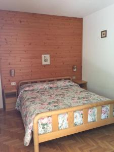 ボルミオにあるAppartamento Hollyの木製の壁のベッドルームのベッド1台