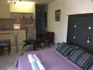 a bedroom with a purple bed and a kitchen at Apartment Eden in Veprinac