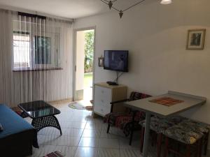 a living room with a table and a tv at Apartment Eden in Veprinac