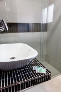 a bathroom sink with a tube of toothpaste on a rack at Pousada do Mano in Fernando de Noronha +44 photos