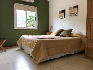 a bedroom with a large bed with a window at Las Lilas Cabañas in La Rioja