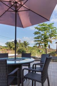 a table and chairs with an umbrella on a patio at Pousada do Mano in Fernando de Noronha
