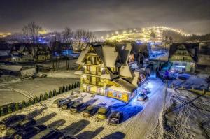 eine Luftaufnahme eines Hauses im Schnee bei Nacht in der Unterkunft Pensjonat Dziubas - 5 minut na piechotę do stacji narciarskiej Kotelnica i term Bania, parking przy obiekcie in Białka Tatrzańska