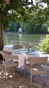 a table with chairs and a table with a view of a river at Hotel Le Rivage in Olivet