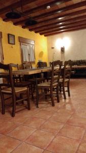 a dining room with a table and wooden chairs at Rural Las Campanas in Torremocha del Pinar