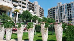 una fila de columnas blancas con flores delante de un edificio en Royal Beach Private Apartments, en Sunny Beach