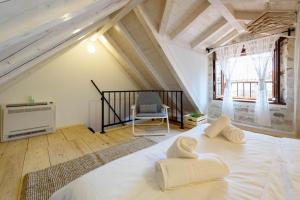 a bedroom with a large white bed in a attic at Apartments & Rooms Tiramola - Old Town in Trogir