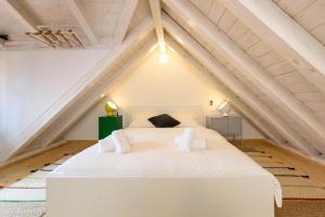 a bedroom with a white bed in the attic at Apartments & Rooms Tiramola - Old Town in Trogir