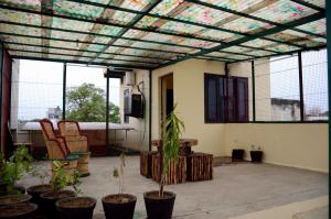 a screened in patio with plants in pots at Mohini Home Stay in Agra