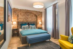 a bedroom with a blue bed and a brick wall at Colonel Suites & Apartments in Rīga