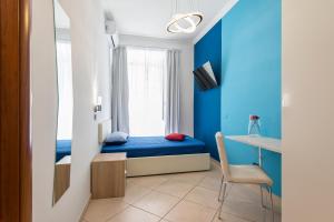 ローマにあるLorenz Suitesのベッドとデスクが備わる小さな客室です。