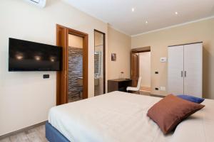 um quarto com uma cama e uma televisão de ecrã plano em Lorenz Suites em Roma