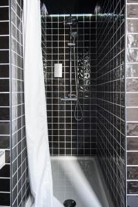 a black tiled bathroom with a tub and a shower at Lemon Tree Stay in Faro