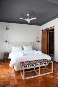a bedroom with a large white bed with a wooden floor at Lemon Tree Stay in Faro
