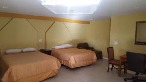 une chambre d'hôtel avec deux lits et une chaise dans l'établissement Budget Motel, à Orlando