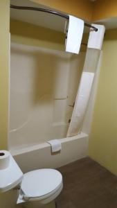 La salle de bains est pourvue de toilettes et d'une baignoire. dans l'établissement Budget Motel, à Orlando