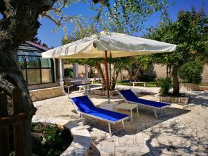 un patio con due sedie e un ombrellone di Villa Iris a Castellana Grotte