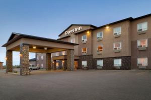 a hotel with a parking lot in front of it at Days Inn by Wyndham Innisfail in Innisfail
