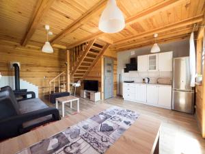 a living room with a couch and a kitchen at Siedlisko Niechorze in Niechorze