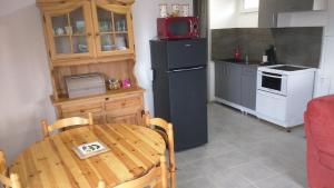 a kitchen with a table and a black refrigerator at Le Mas de la Tortue (Toit Terrasse) in Caromb