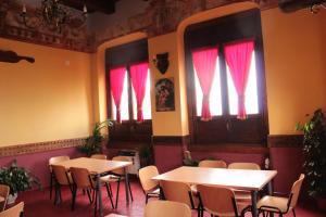 un restaurant avec des tables, des chaises et des rideaux rouges dans l'établissement S.Maria degli Angeli C. Ospitalità, à Alvignanello