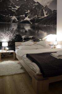 コシチェリスコにあるApartamenty pod blachówkąのベッドルーム1室(山の壁画のある大型ベッド1台付)