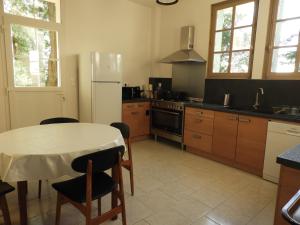 eine Küche mit einem Tisch und einem weißen Kühlschrank in der Unterkunft Bellevue in Écommoy