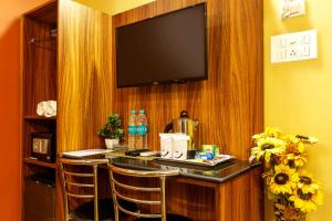 a bar in a hotel room with a flat screen tv at The Silverline Hotel in Kolkata