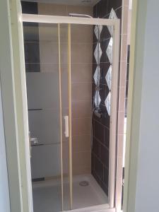 a shower with a glass door in a bathroom at Maison Provost in Le Croisic