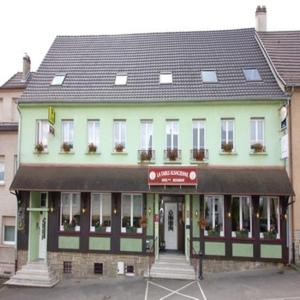 un grand bâtiment vert avec un toit noir dans l'établissement La Table Alsacienne, à Farébersviller