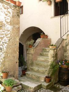 una scala in pietra che conduce a un edificio con piante in vaso di Residence Il Palazzo a Santo Stefano di Sessanio